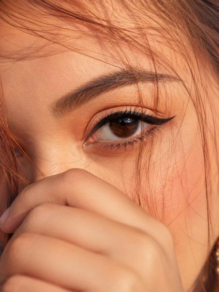 Ultra-realistic cinematic macro close-up portrait of a single human eye with strict eye identity preservation, golden-hour lighting, and editorial beauty photography.